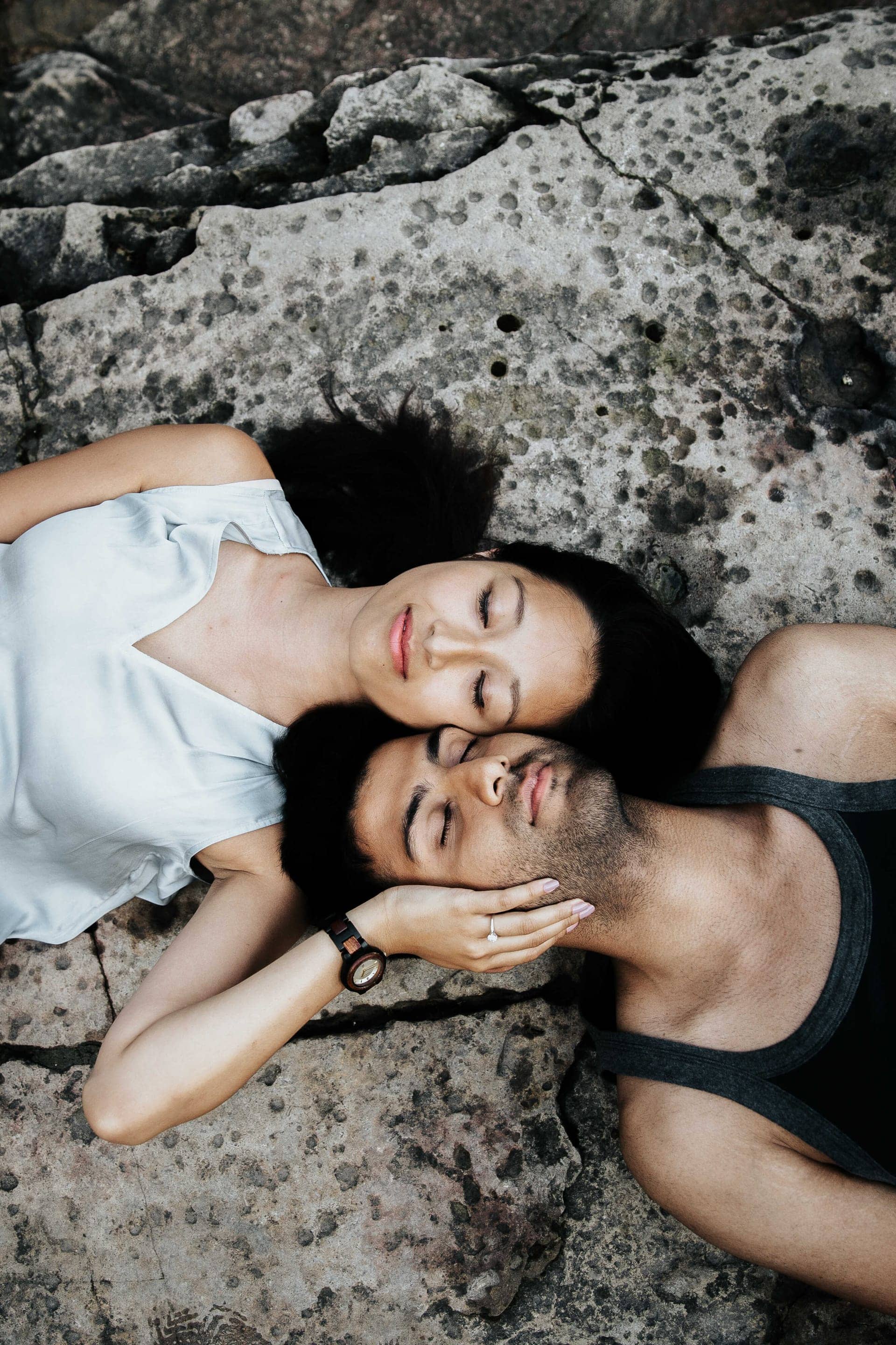 Amir Khela and Samantha Khela lying side by side on a rock, heads together